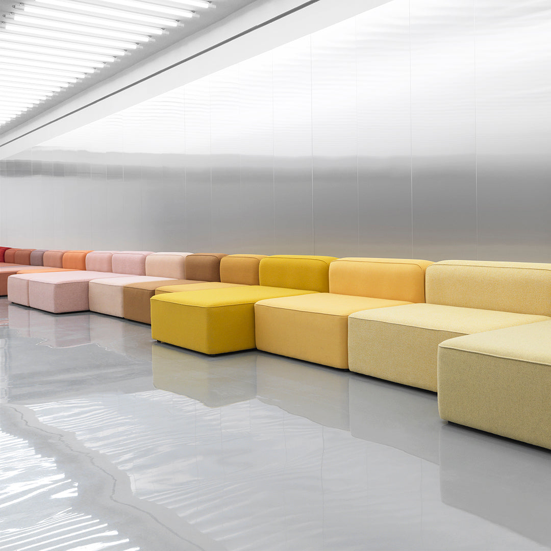 Colorful modular sofa in shades of pink, yellow, and orange, featuring a modern, minimalist design.