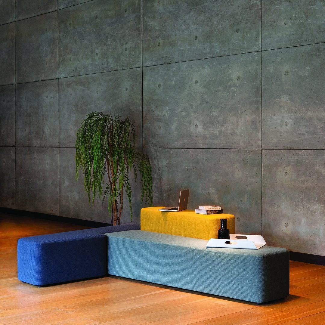 Modern seating in blue, green, and yellow hues, featuring sleek, minimalist design and soft textures.