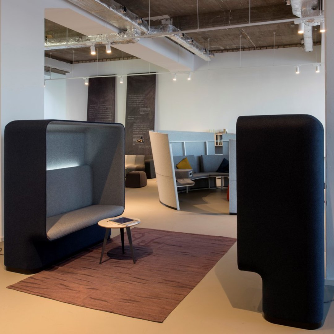 Modern gray and black seating area with geometric rug in a contemporary indoor space.