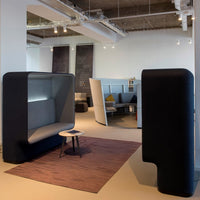 Modern gray and black seating area with geometric rug in a contemporary indoor space.