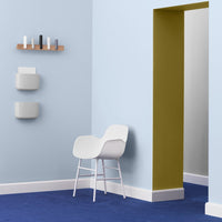 Light blue walls, vibrant blue carpet, olive green accent wall, and minimalist white chair for a modern aesthetic.