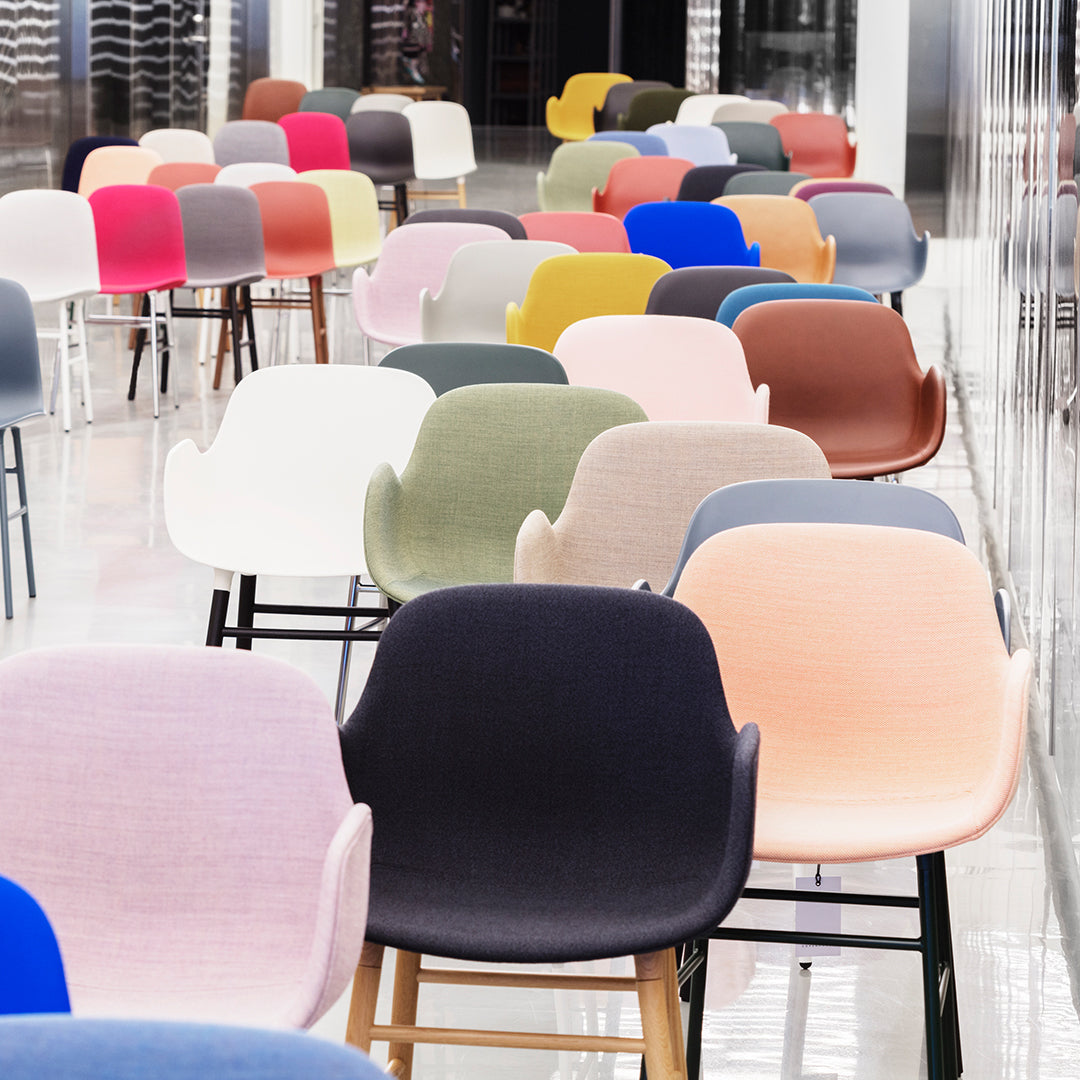 Multicolored chairs in shades of pink, blue, green, and beige, featuring smooth fabrics and modern designs.
