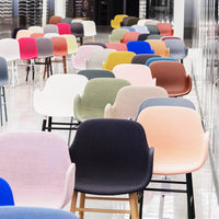 Multicolored chairs in shades of pink, blue, green, and beige, featuring smooth fabrics and modern designs.