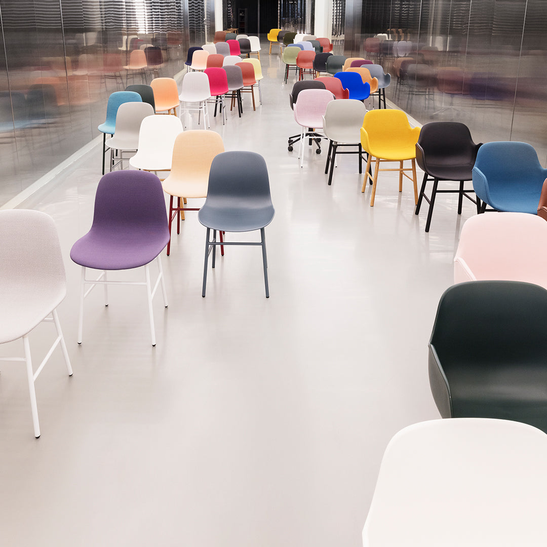 Colorful modern chairs in pastel shades and vibrant hues arranged in a sleek, minimalistic setting.