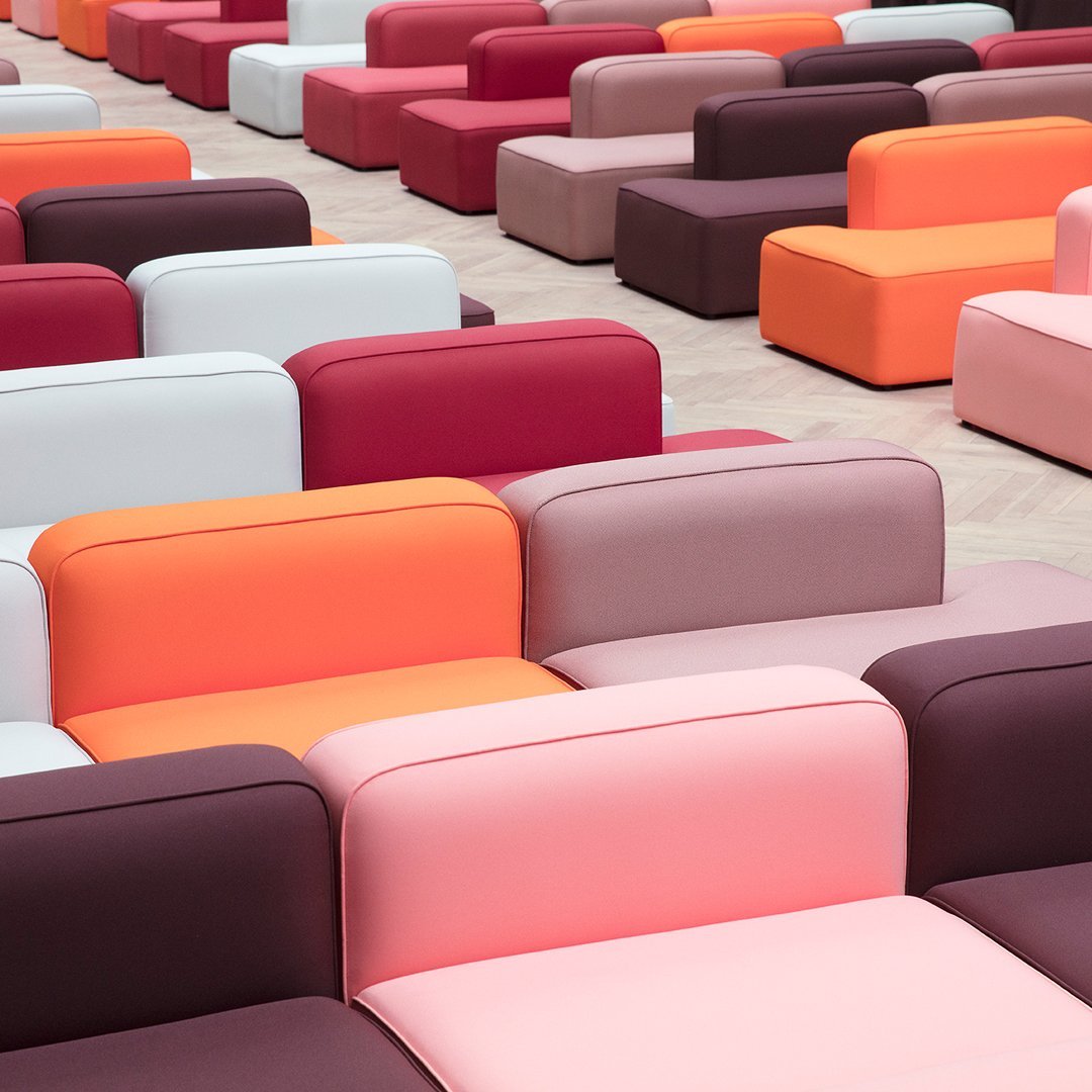 Colorful modular seating in shades of pink, red, orange, white, and purple with a contemporary design pattern.