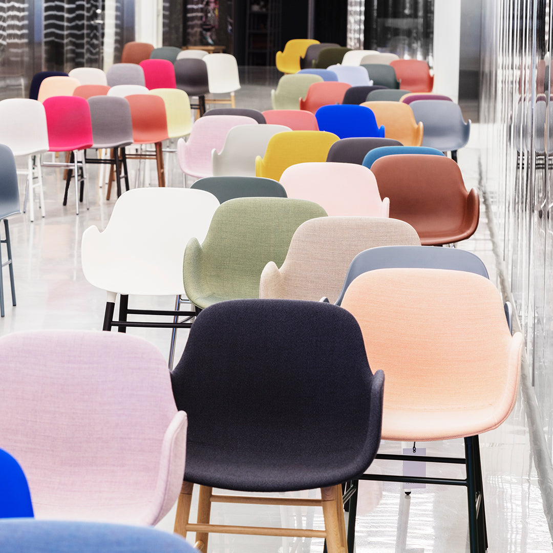 Colorful array of modern chairs featuring pink, blue, green, white, and gray hues with various textured patterns.