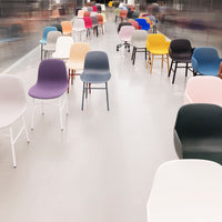 Colorful modern chairs in various patterns and hues, including pastels and bold shades, arranged in a sleek setting.