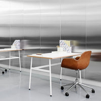 "Modern workspace featuring a sleek brown chair, white desk, and patterned organizer against a reflective silver backdrop."