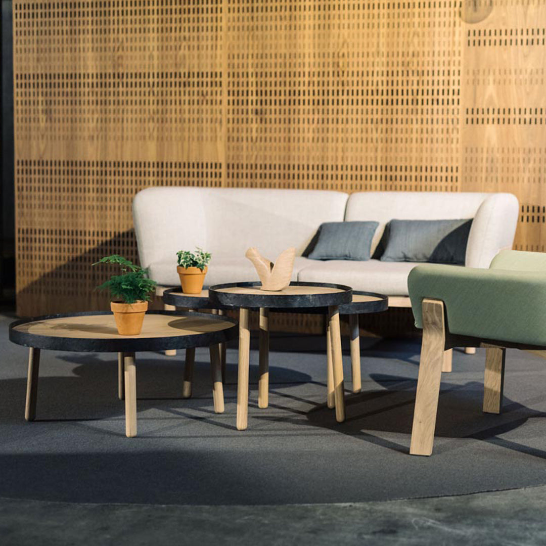 Modern coffee tables featuring a mix of black and natural wood tones, with sleek round designs and minimalist style.
