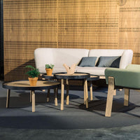 Modern coffee tables featuring a mix of black and natural wood tones, with sleek round designs and minimalist style.