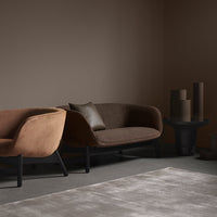 "Two stylish sofas in rich brown shades, soft textures, and modern black legs, against a minimalist neutral backdrop."