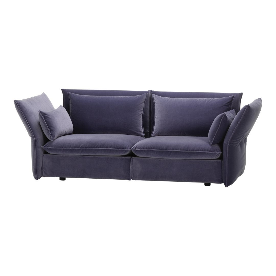 Purple velvet sofa with bold geometric cushions and a modern, sleek design. Perfect for contemporary decor.