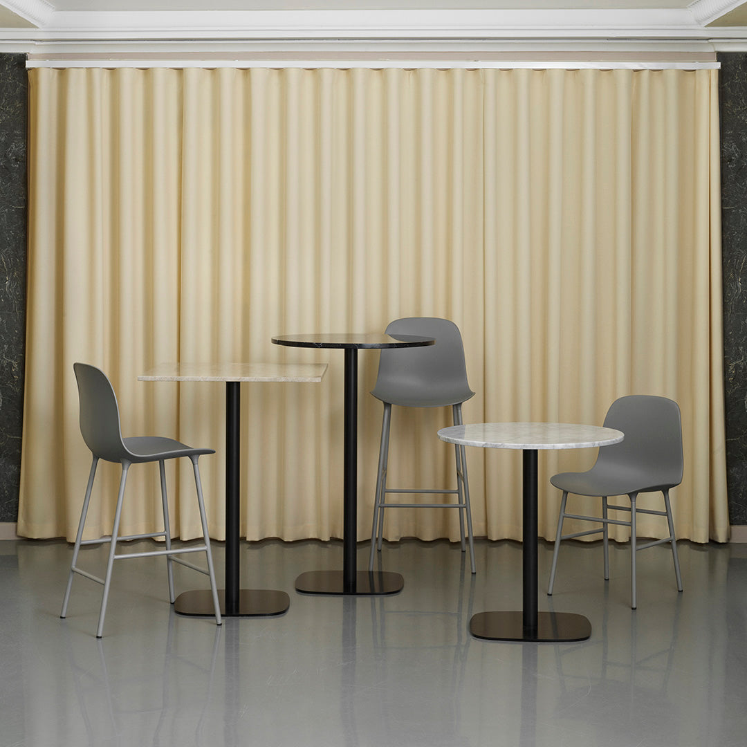 "Modern gray stools and tables with black bases against a soft beige backdrop, creating a stylish, contemporary look."