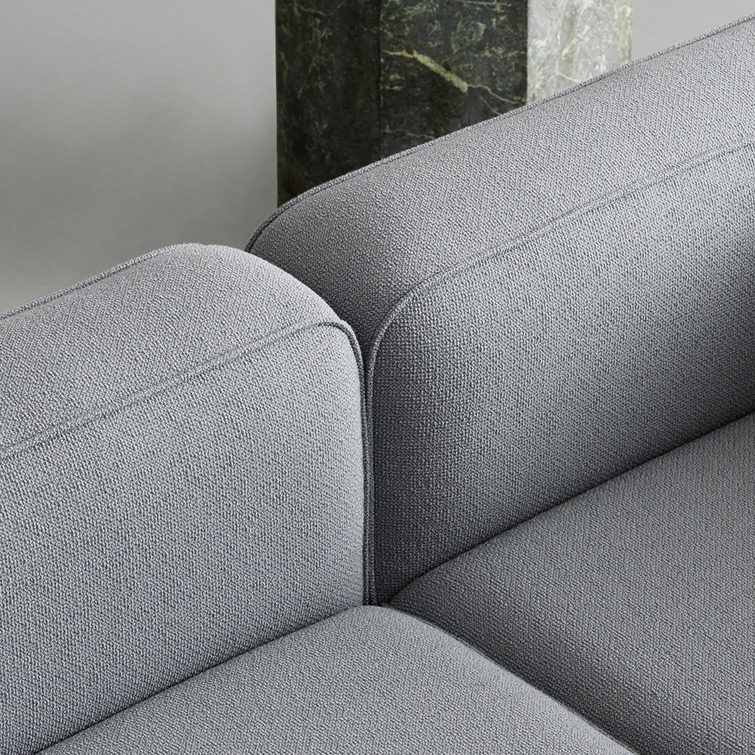 Gray textured upholstery of a modern sofa with soft, rounded edges and clean lines. Perfect for contemporary interiors.