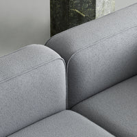 Gray textured upholstery of a modern sofa with soft, rounded edges and clean lines. Perfect for contemporary interiors.