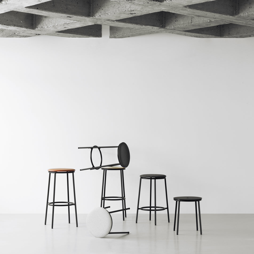 Colorful modern bar stools in black, white, and natural wood on a minimalist background, featuring sleek, simple designs.