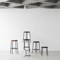 Modern bar stools in black with wood accents, showcasing a minimalist design against a white background.