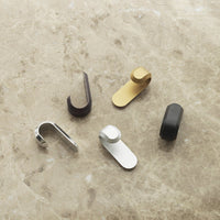 Set of five sleek metal clips in gold, silver, black, and dark brown, showcasing modern minimalist design.