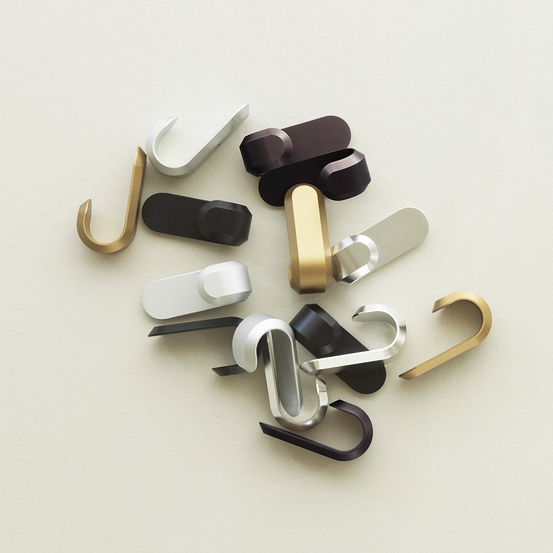 Assorted hooks in gold, silver, black, and brown with sleek, modern designs on a neutral background.
