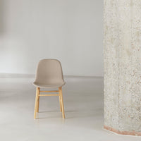Beige chair with a smooth finish and natural wood legs, set against a minimalist, light gray background.