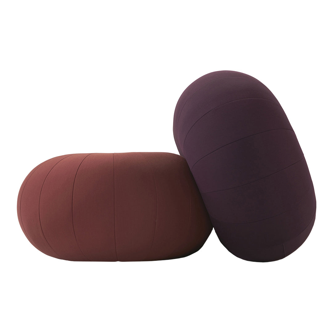 "Two oval cushions in rich burgundy and deep purple with smooth, textured patterns."