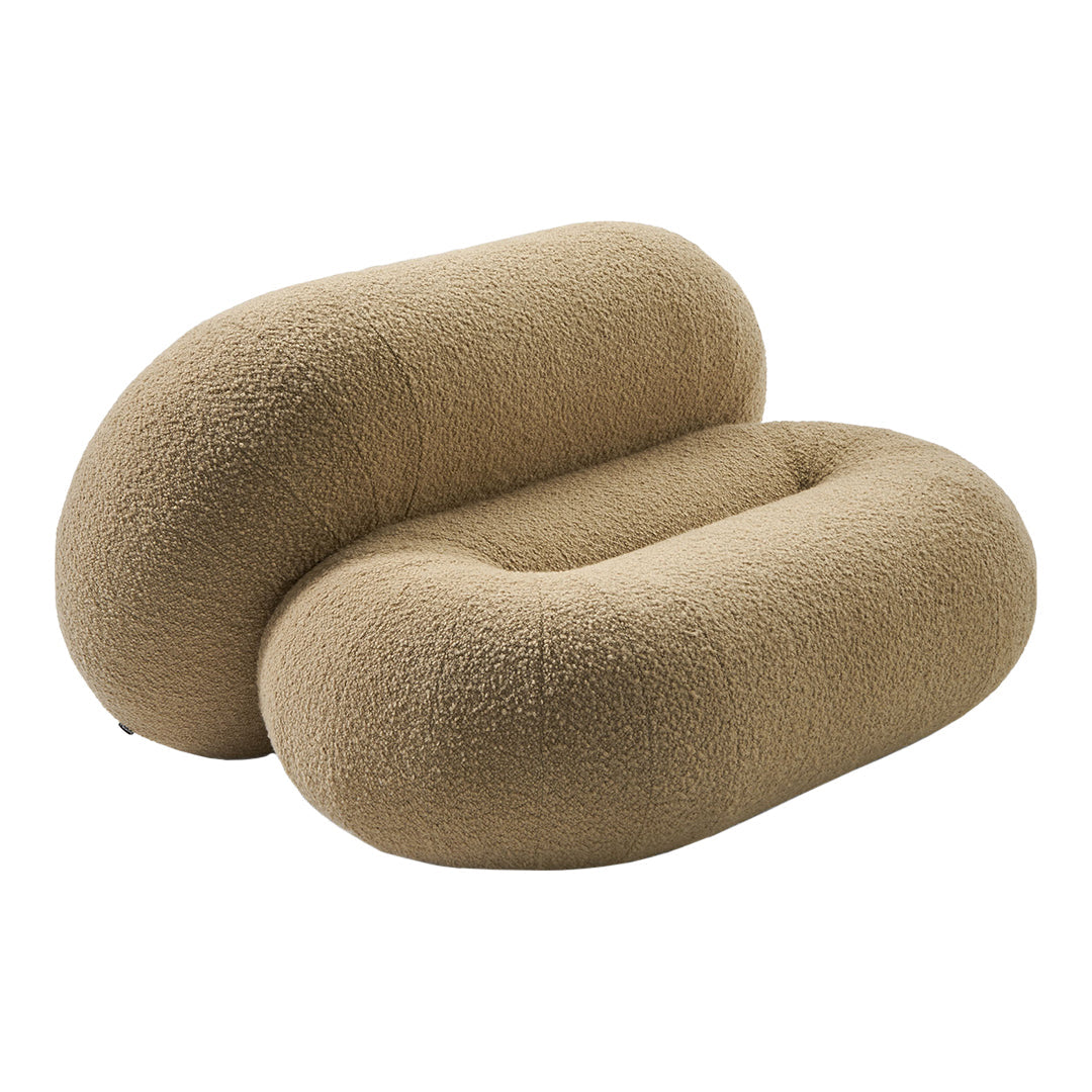 Cozy beige boucle fabric bolster pillow with a unique curved shape and soft texture, perfect for stylish decor.