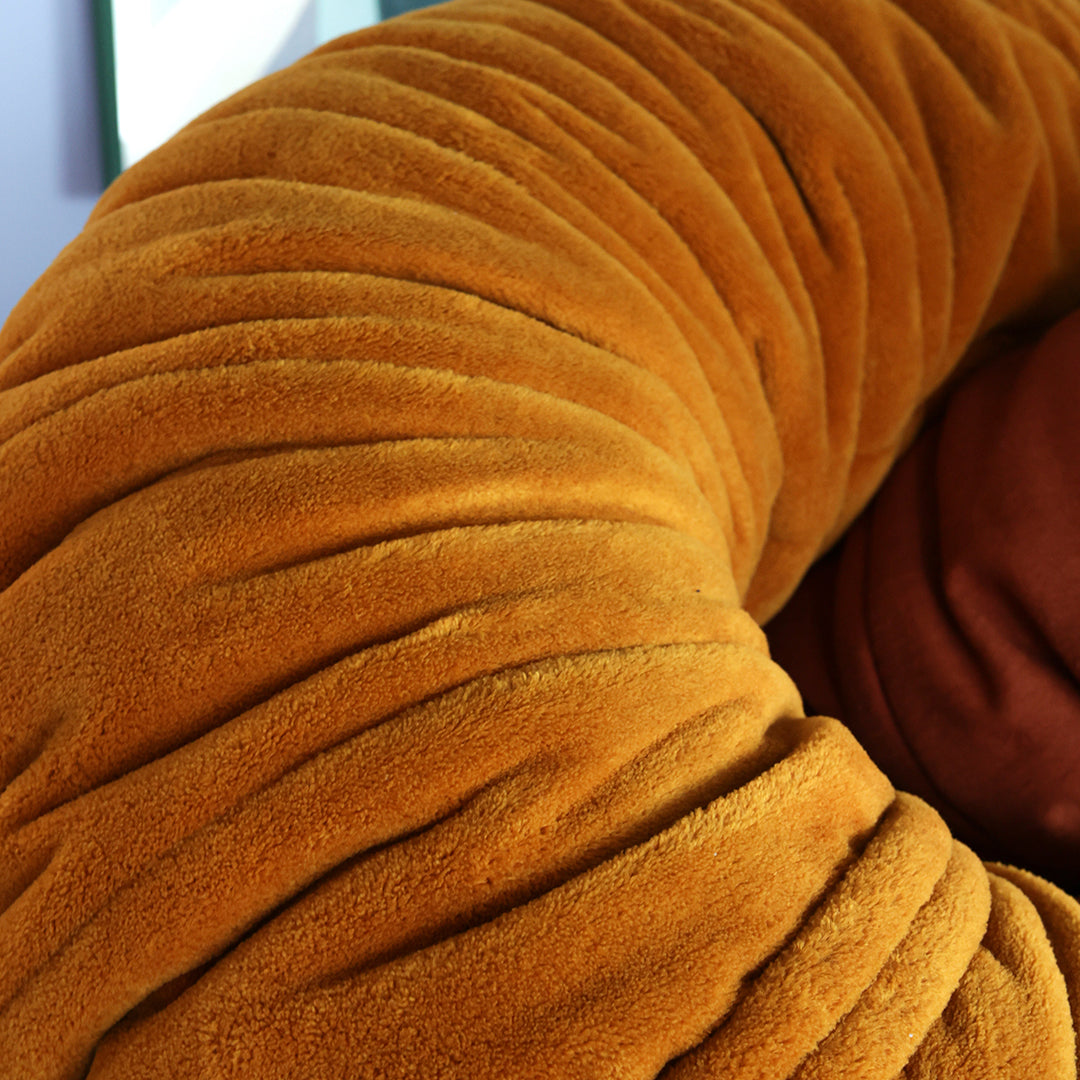 Textured orange fabric with plush folds, showcasing a cozy and inviting design. Ideal for modern decor.