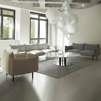 Stylish gray and cream sofas with a sleek gray area rug and white spherical pendant lights in a modern living room.