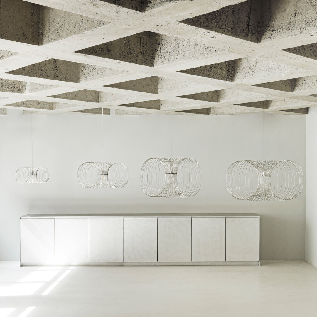 Modern white pendant lights against a textured gray ceiling and sleek white cabinetry. Minimalist design with clean lines.