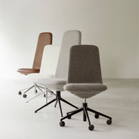 Four office chairs in brown, white, grey, and beige fabrics with sleek black bases on a minimalist white floor.