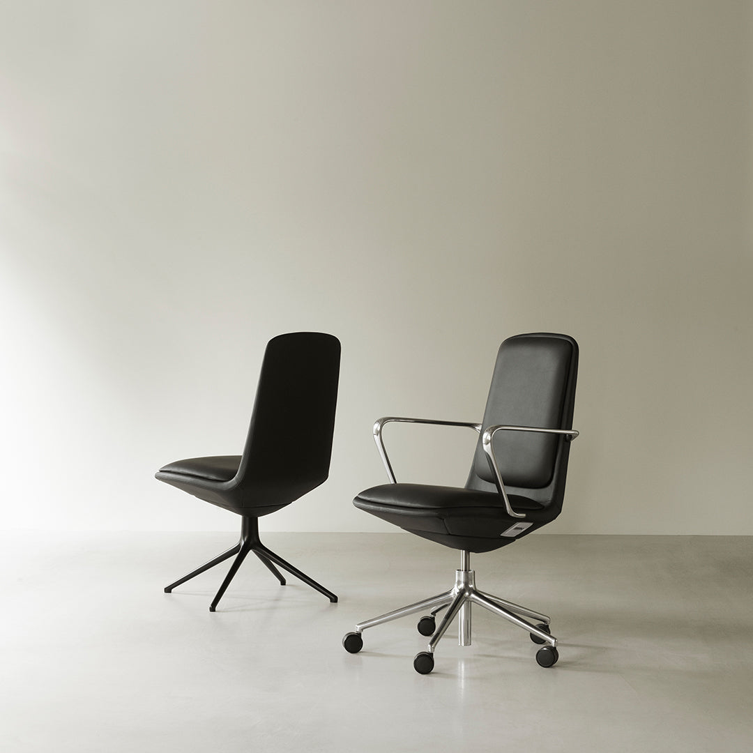 Black leather office chairs with sleek designs and contrasting chrome accents on a minimalist background.