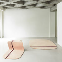 Two abstract rugs featuring soft beige hues with deep maroon stripes against a minimalist white background.