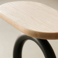 Light wood grain top with smooth edges and a sleek black curved base for a modern, minimalist look.