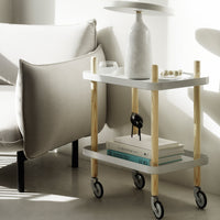 Modern white rolling cart with natural wood legs and minimalist design, perfect for stylish home decor.