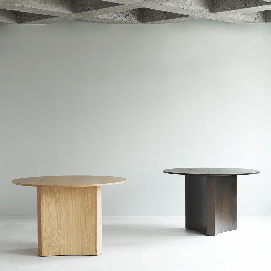 Natural wood grain in light oak and dark walnut finishes; sleek round shape and minimalist design.