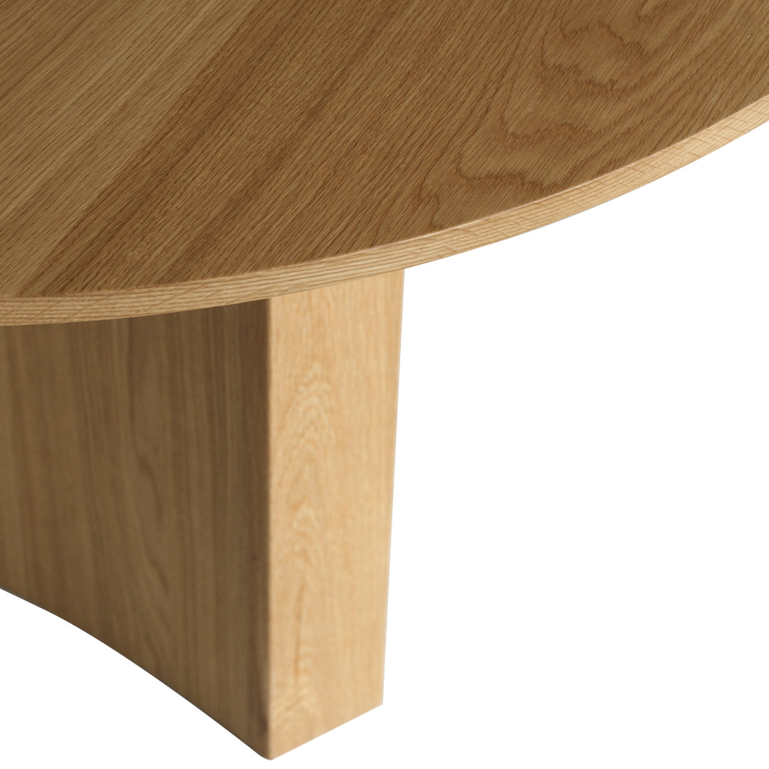 Light oak wood table with a smooth, natural grain pattern and a round top, showcasing a minimalist design.