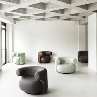 Modern chairs in soft pastel green, brown, and gray fabrics, featuring unique rounded designs and a minimalist aesthetic.