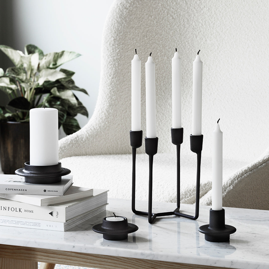 Black and white candle holders with sleek, modern design against a neutral backdrop.