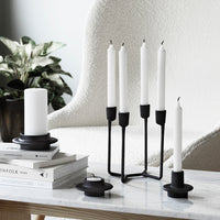Black and white candle holders with sleek, modern design against a neutral backdrop.
