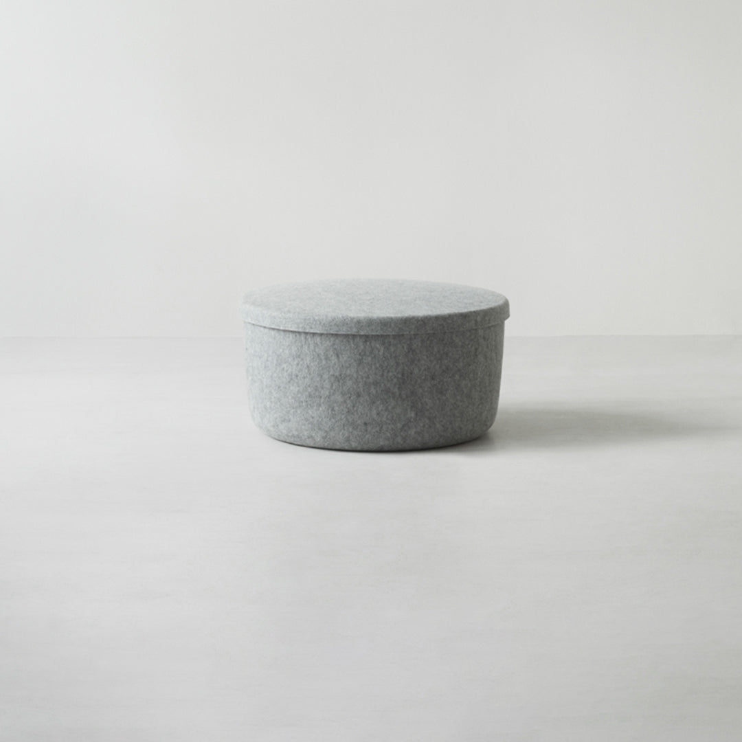 Soft gray round storage container with a minimalistic design and a textured felt pattern. Ideal for modern decor.