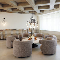 Textured beige upholstered chairs with a speckled pattern, set around a round white marble table in a modern space.