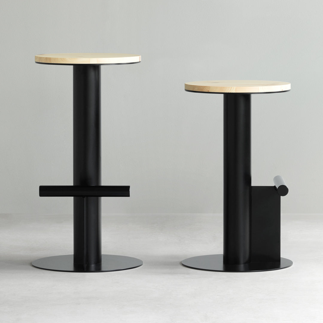 "Black and natural wood bar stools with minimalistic design and round tops, featuring smooth, contrasting surfaces."