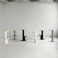 Set of modern bar stools in white, black, gray, and natural wood finishes, featuring sleek, minimalist designs.