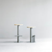 Two modern bar stools featuring a minimalist gray base and natural wood tops, complementing any contemporary decor.