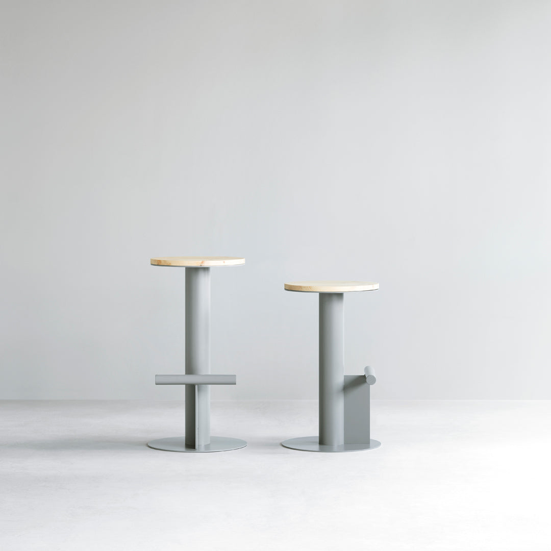 Pair of minimalist bar stools with natural wood tops and sleek gray metal bases, perfect for modern decor.