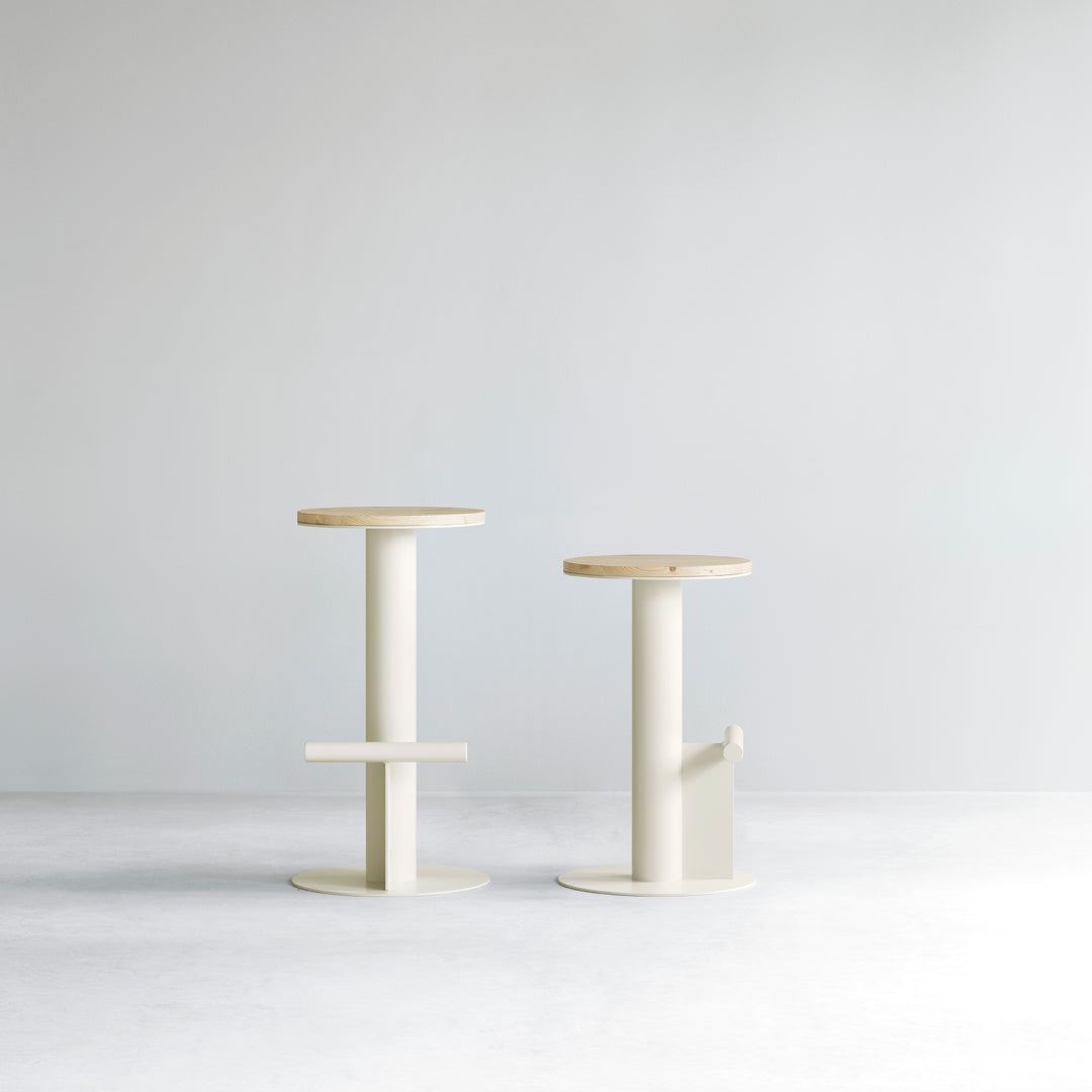 Modern minimalist stools in soft cream and natural wood tones, featuring smooth lines and a simplistic design.