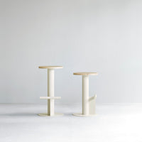 Modern minimalist stools in soft cream and natural wood tones, featuring smooth lines and a simplistic design.
