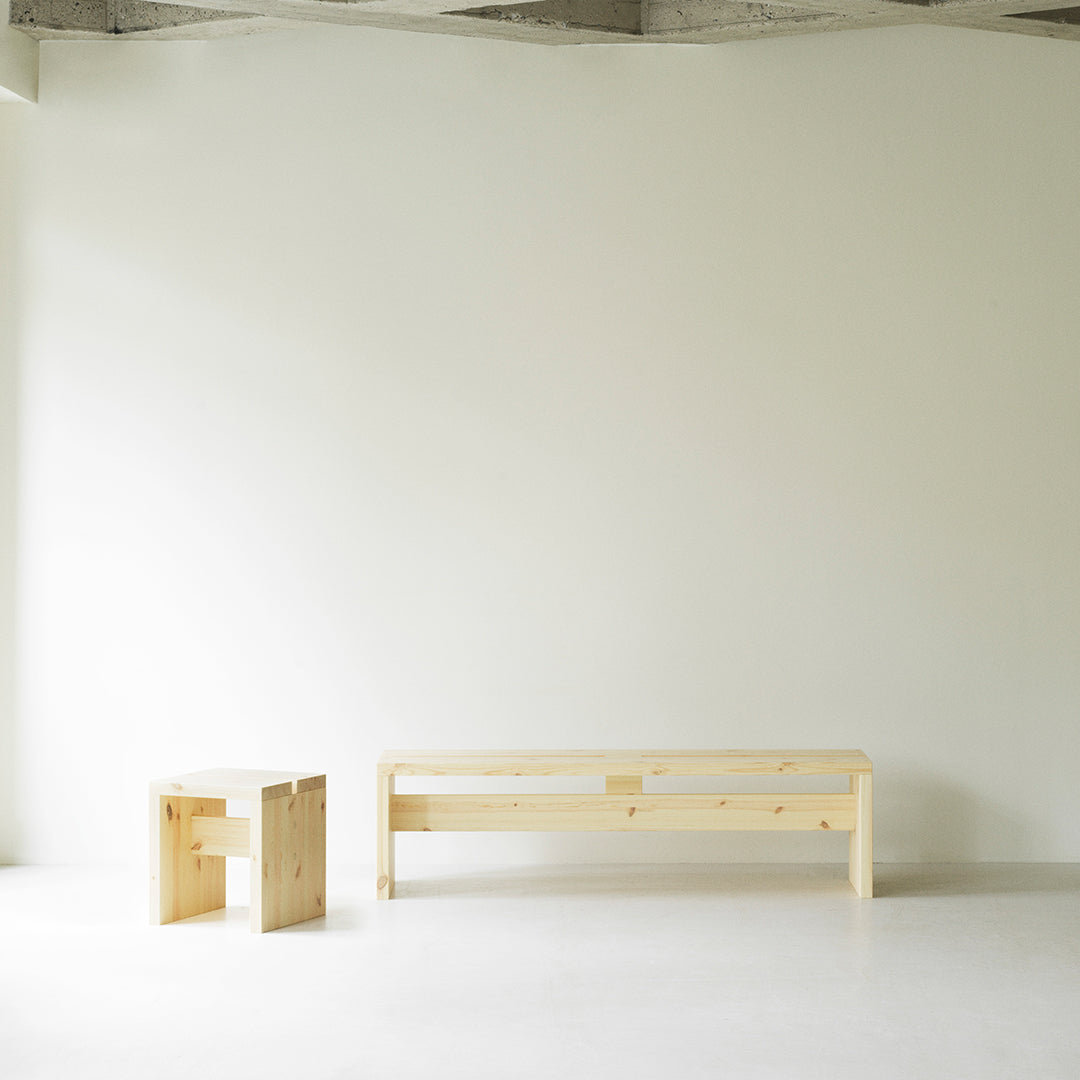Natural wood furniture in light pine color, minimalist design with smooth surfaces and simple geometric shapes.