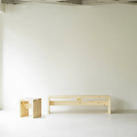 Natural wood furniture in light pine color, minimalist design with smooth surfaces and simple geometric shapes.