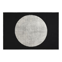 Black rug featuring a large white circular pattern, ideal for modern decor. Perfect contrast for stylish interiors.